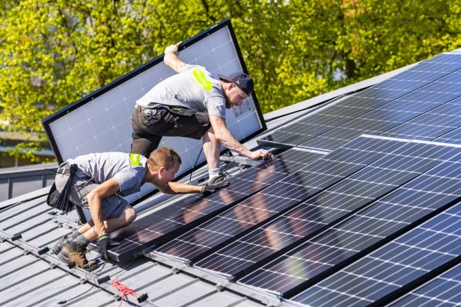 Monteurs leggen zonnepanelen op een dak