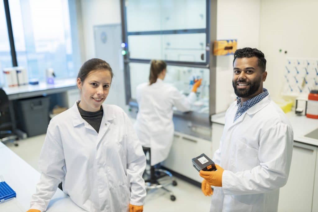 Biotechteam bespreekt onderzoeksdata en innovatieplannen in een laboratorium